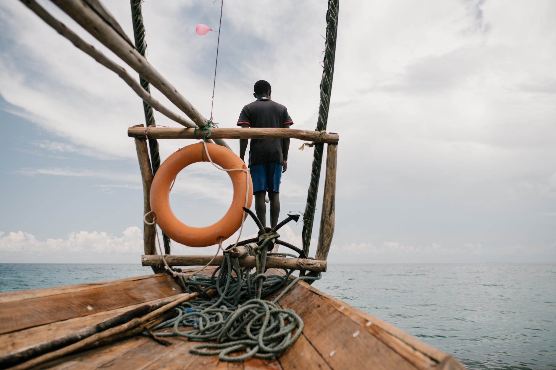 unrecognizable man on sailboat in sea